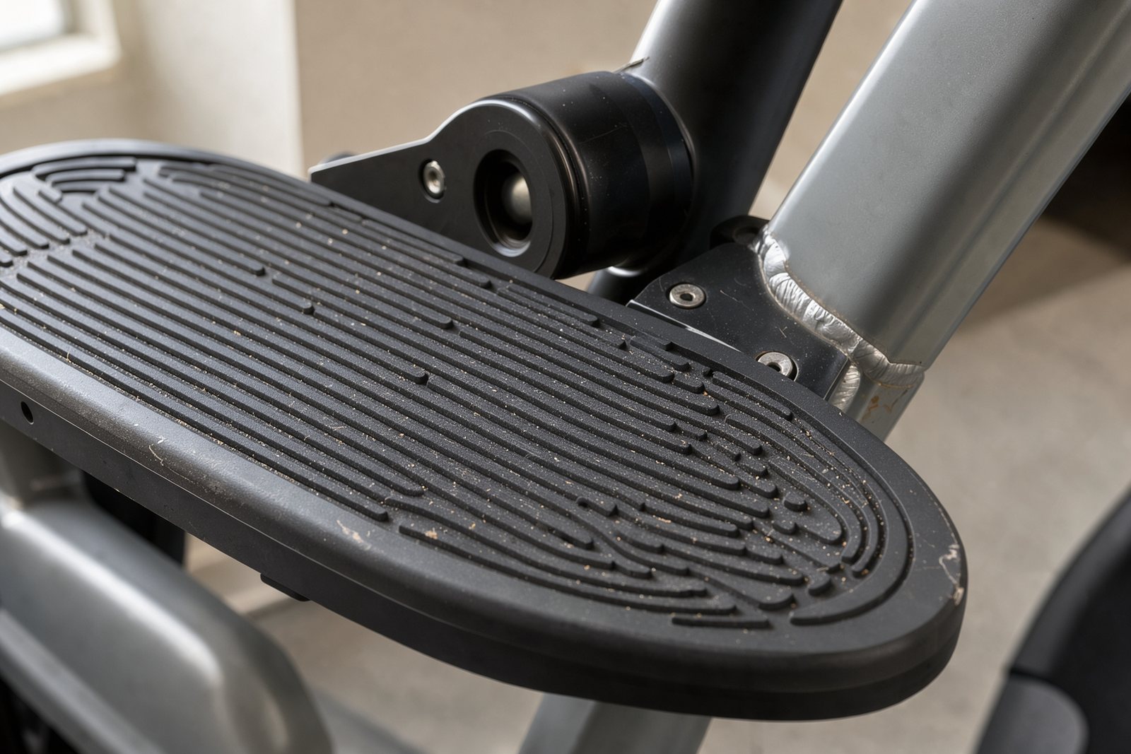 Symbolische Detailaufnahme von Trittfläche und Gelenk eines Crosstrainers